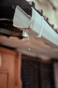 富山の住宅の軒先で雨どいから流れ落ちる雨水