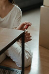 ドライバー工具を使って室内で家具を組み立てる様子